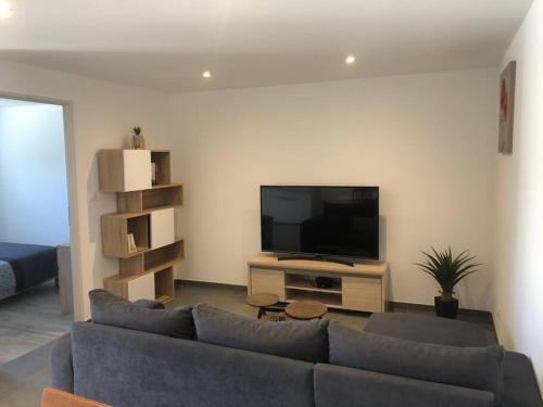 un salon avec un canapé et une télévision à écran plat dans l'établissement Appartement neuf dans villa, à Aiglun