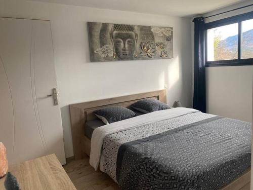 une chambre avec un lit et un tableau au mur dans l'établissement Appartement neuf dans villa, à Aiglun