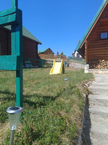 a yard with a playground with a slide at Durmitorski cvijet in Žabljak