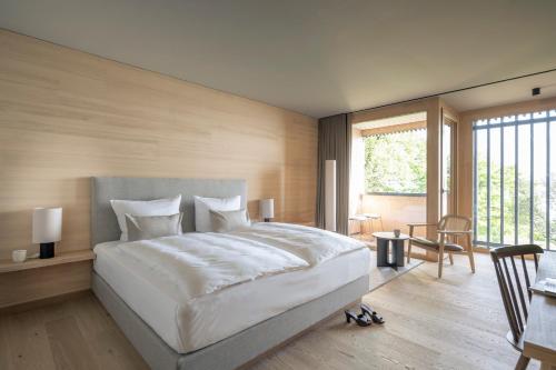 a bedroom with a large white bed and a large window at Seegut Zeppelin in Friedrichshafen