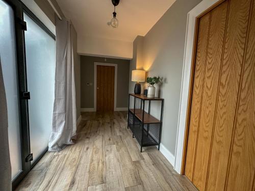 a hallway with a wooden floor and a door at The Hideaway - Luxury Country Retreat in The Trench