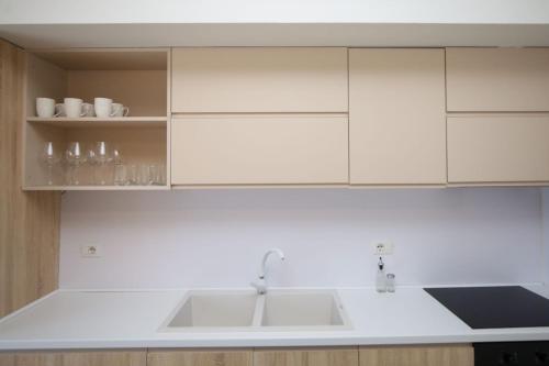 a kitchen with white cabinets and a sink at Seaside Apartments in Vlorë