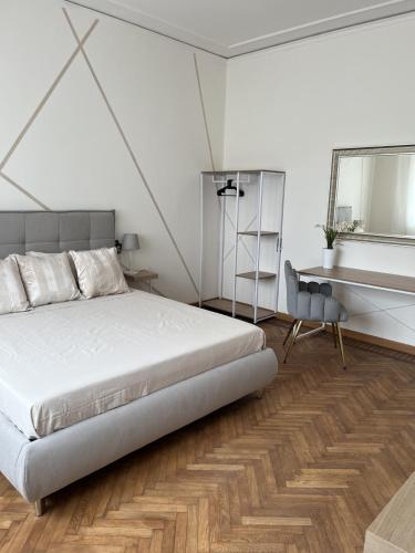 a bedroom with a bed and a desk and a mirror at Villa Diana in Montecatini Terme