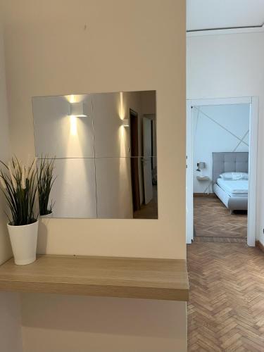 a mirror on the wall of a room with a bed at Villa Diana in Montecatini Terme