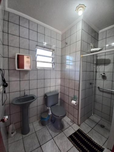 a bathroom with a toilet and a sink and a shower at Chalés Luz Da Lua in Caraguatatuba