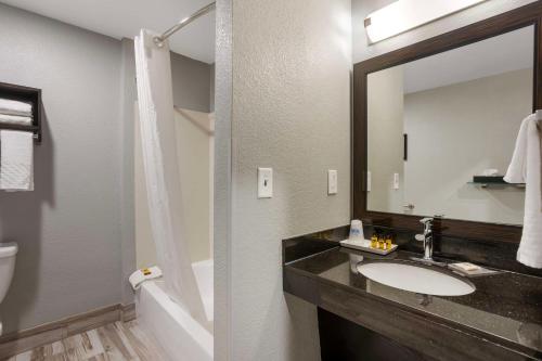 a bathroom with a sink and a toilet and a mirror at Best Western Plus Columbia Inn in Columbia
