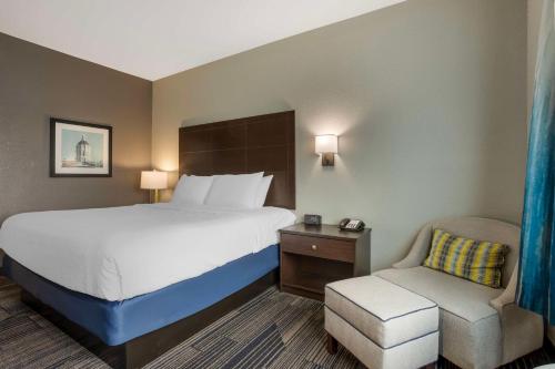 a hotel room with a bed and a chair at Best Western Plus Columbia Inn in Columbia