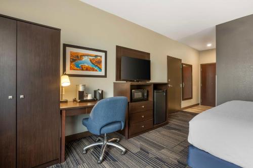 a hotel room with a bed and a desk with a computer at Best Western Plus Columbia Inn in Columbia