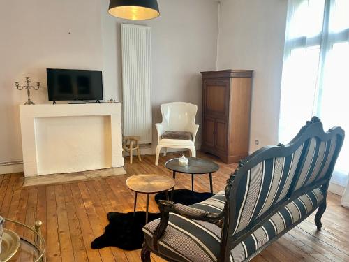 Il comprend un salon doté d'une cheminée, d'une chaise et d'une télévision. dans l'établissement le 888 Demeures Grand T2 de charme dans centre Saumur, à Saumur
