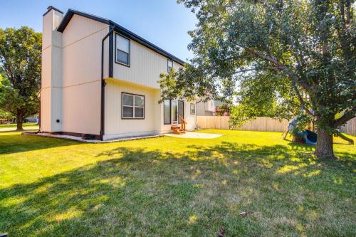 a house with a tree in a yard at Spacious Olathe Home with Fireplace Near Parks! in Olathe