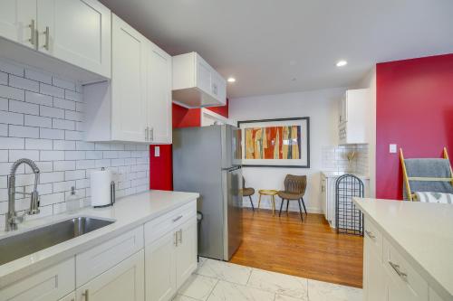 a kitchen with white cabinets and red walls at Pet-Friendly Houston Apartment 1 Mi to Downtown! in Houston
