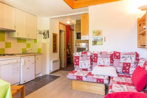 un salon avec un canapé et une cuisine dans l'établissement Résidence Le Bastion I - Appartement en duplex spacieux MAE-0284, à Aime La Plagne