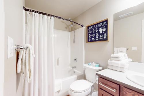 a white bathroom with a toilet and a sink at The Riverhouse in Sunriver