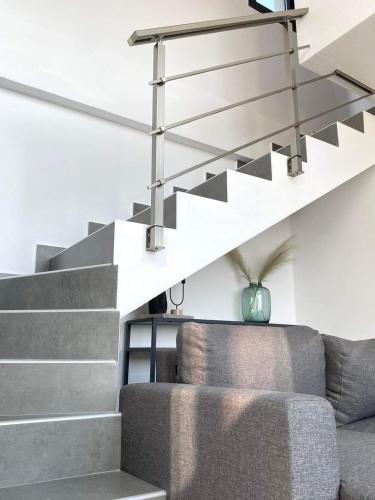 a living room with a staircase and a couch at Saos Terra Suites in Samothráki