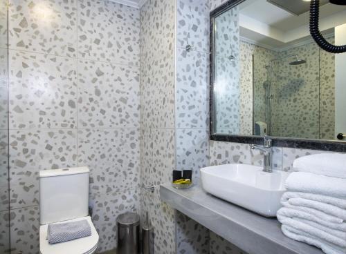 a bathroom with a sink and a mirror at Selini Suites & Waterpark in Kolymvari