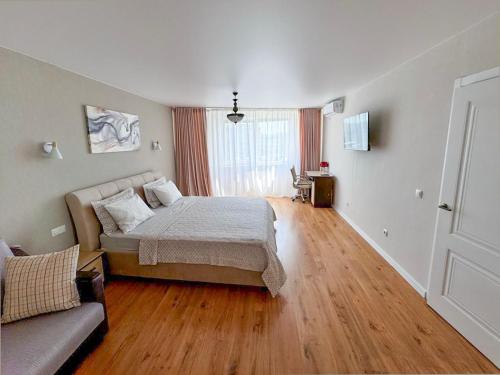 a bedroom with a bed and a couch at Charming,lovely and central with park view in Chişinău