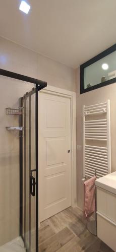 a bathroom with a shower and a white door at Home trani in Trani