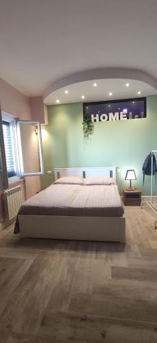 a bedroom with a bed and a sign on the wall at Home trani in Trani