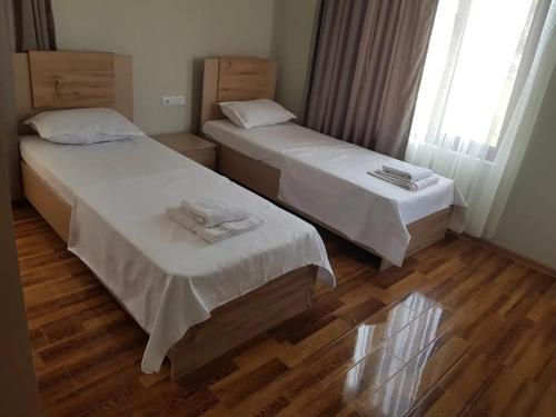 two beds in a room with wooden floors at VILLA DlAS in Ureki