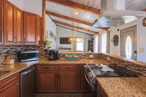 a large kitchen with wooden cabinets and a stove at Relaxing 3BR Cottage 1 mile to Main st attractions Views in Gatlinburg