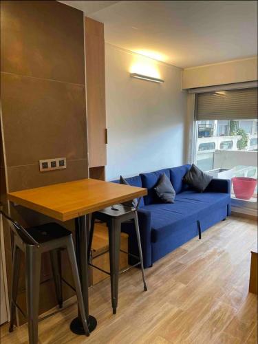 un salon avec un canapé bleu et une table dans l'établissement Paris Esplanade 701, à Courbevoie