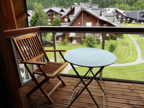 d'une table en verre et d'une chaise sur un balcon. dans l'établissement Résidence Combettes - Combettes D300 MAE-4071, aux Contamines-Montjoie