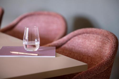 a wine glass sitting on a table with two chairs at Seegut Zeppelin in Friedrichshafen