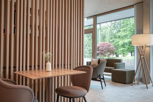 a living room with a table and chairs and a large window at Seegut Zeppelin in Friedrichshafen