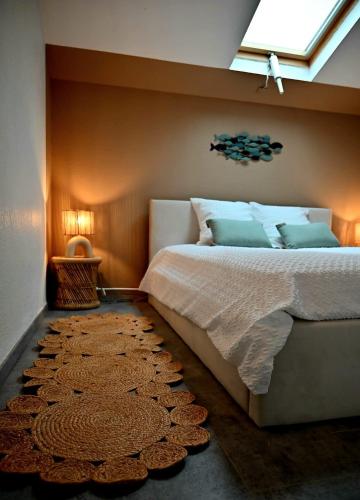 - une chambre avec un lit, une fenêtre et un tapis dans l'établissement Duplex de charme en bord de mer, à Sanary-sur-Mer