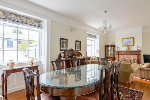 a dining room and living room with a glass table at The Old Surgery in Limavady