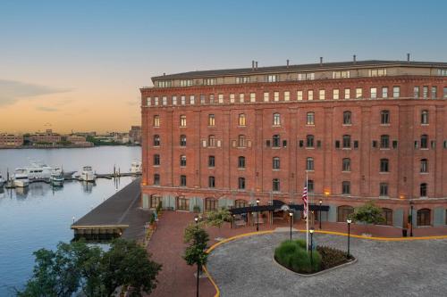 a large red brick building next to a body of water at The Inn at Henderson's Wharf, an Ascend Collection Hotel in Baltimore