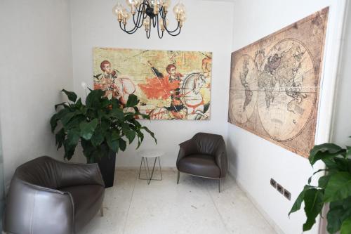 a room with two chairs and a painting on the wall at Hotel Gega in Berat