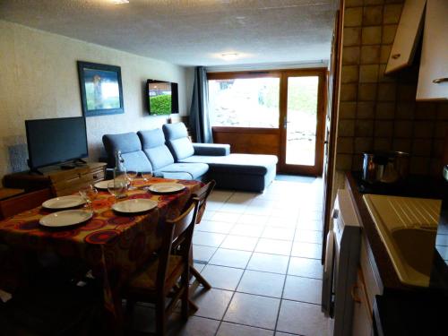 un salon avec une table et un canapé dans l'établissement Résidence L'air Du Temps - L'Air du Temps 10 MAE-1321, aux Contamines-Montjoie