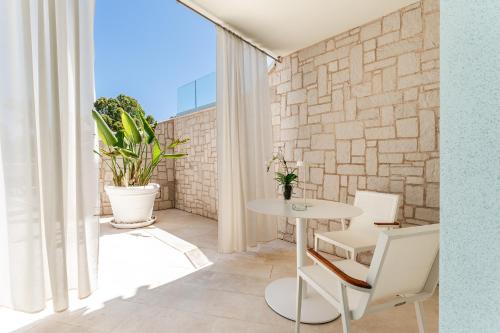a table and chairs in a room with a brick wall at Oasi Blu Sardinia in Santa Margherita di Pula