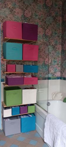une pile de boîtes sur le mur d'une salle de bain dans l'établissement Maison BnB pour JO pas loin du centre de Paris, à Asnières-sur-Seine