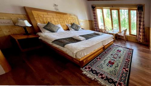 a bedroom with a large bed and a rug at Hotel Namgyal Villa in Nubra