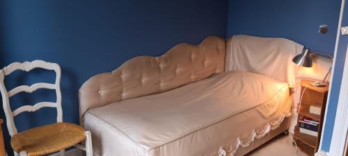 un canapé blanc dans une pièce avec un mur bleu dans l'établissement Maison BnB pour JO pas loin du centre de Paris, à Asnières-sur-Seine