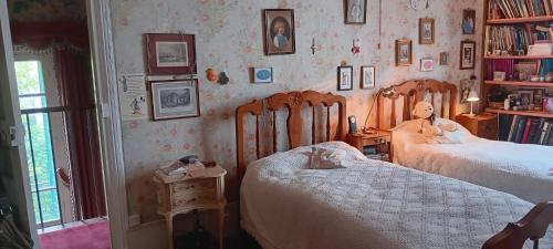 une chambre avec deux lits et une étagère dans l'établissement Maison BnB pour JO pas loin du centre de Paris, à Asnières-sur-Seine