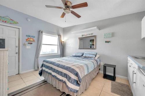 Wave condo في سانت بيتي بيتش: غرفة نوم بها سرير ومروحة سقف