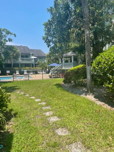 a stone path in a yard with a tree at The Brighton on the Marsh in Riverview