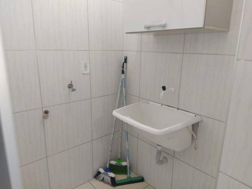 a bathroom with a sink and a mop on the wall at Apartamento Encantador 201 in Vitória da Conquista