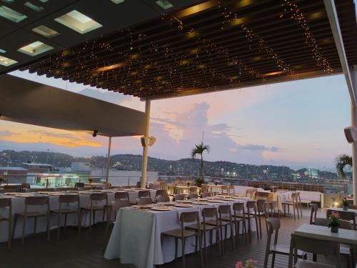 a banquet hall with white tables and chairs and a view at Hotel CasaBlanca Cucuta in Cúcuta