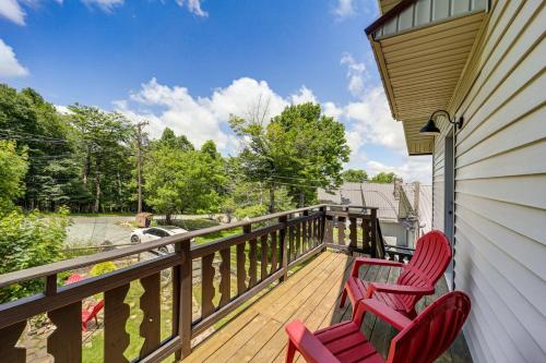 two red chairs sitting on the porch of a house at 1 Mi to Beech Mtn Ski Resort Home with Large Yard in Beech Mountain