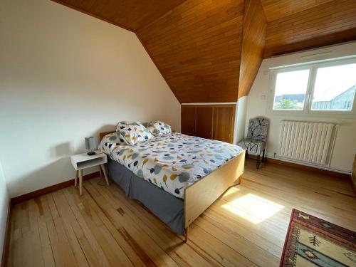 a bedroom with a bed with a wooden ceiling at Ty Queff Lodge in Plonévez-Porzay
