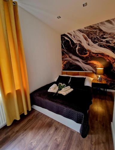 a bedroom with a bed with a painting on the wall at 4 You in Bolesławiec
