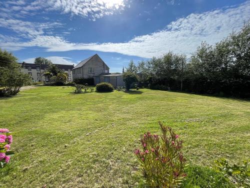 a large yard with a house in the background at Ty Queff Lodge in Plonévez-Porzay