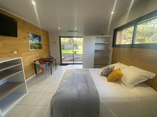 a bedroom with a bed and a desk and a television at L'Oustal Des Dômes in Orcines
