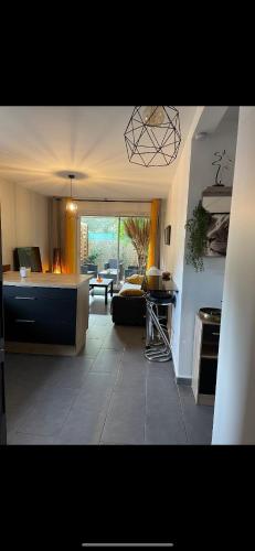 une cuisine et un salon avec un canapé et une table dans l'établissement Agréable T2 traversant RDC avec terrasse - balcon - Parking 2 places - Clim portative, à Montpellier