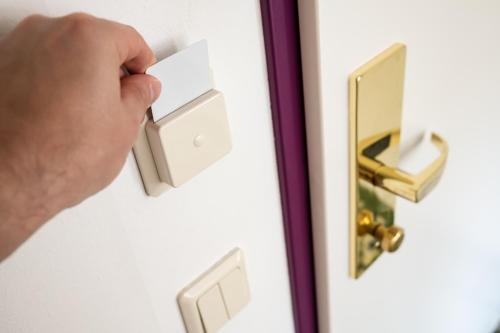 a man unlocking a door with a door knob at RG Boutique Hotel in Yerevan