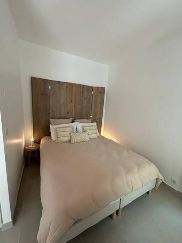 une chambre avec un grand lit avec une tête de lit en bois dans l'établissement Studio Wish 5 min Disney Parking, à Chessy